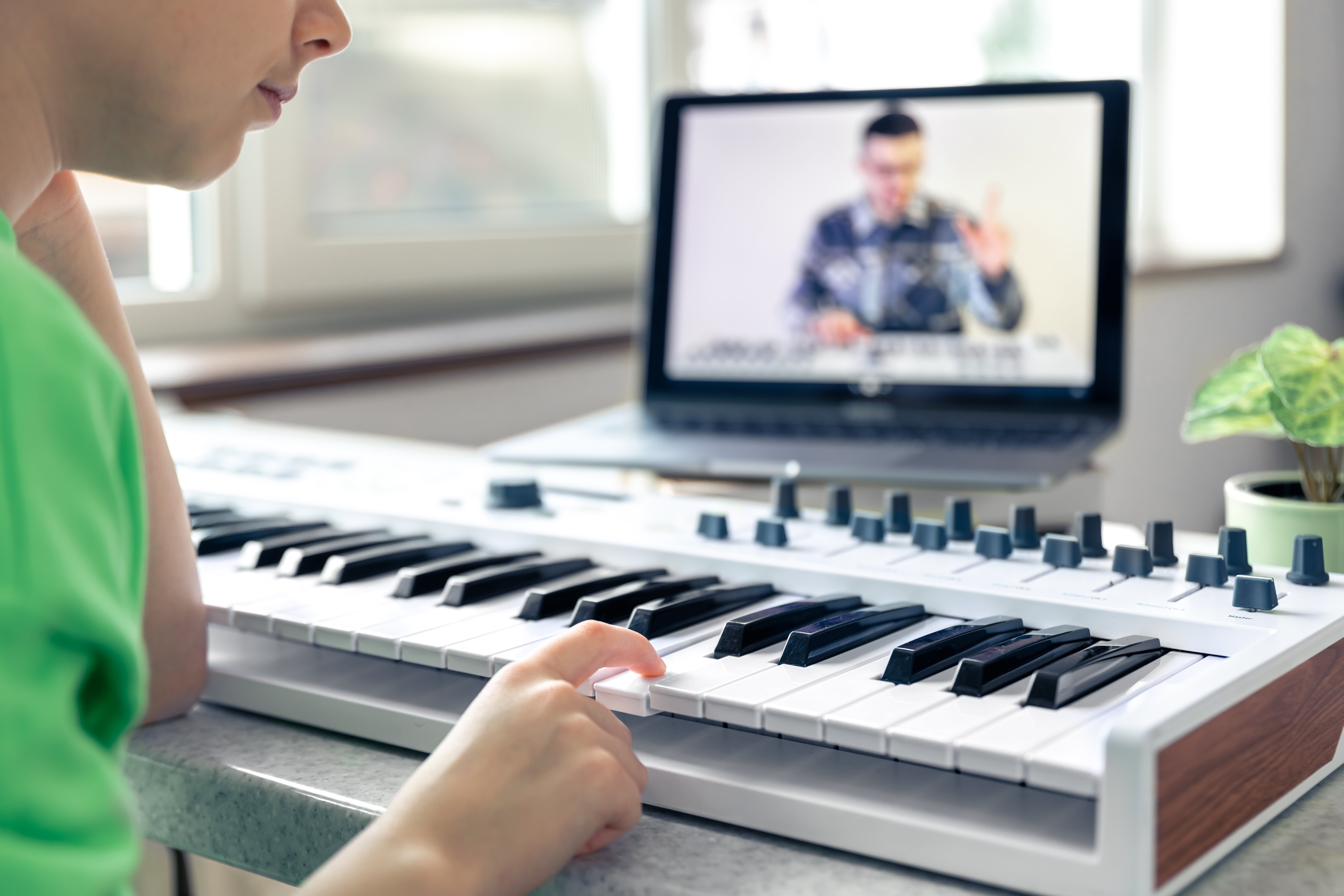 girl-learns-play-piano-with-teacher-online-remote-learning-music